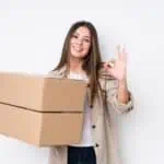 Young caucasian woman moving to a new home cheerful and confident showing ok gesture.