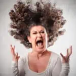 Very angry woman screaming her hair up in the air