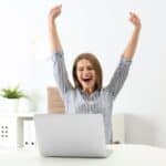 excited woman sitting at computer