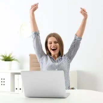 excited woman sitting at computer