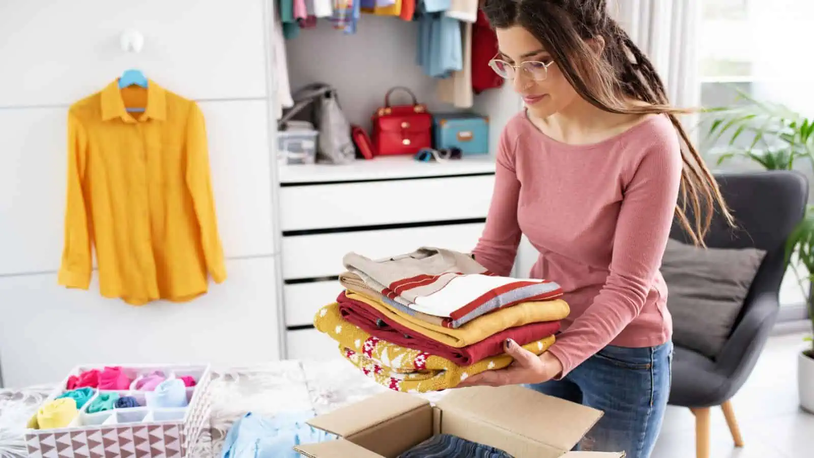 woman putting clothes in box