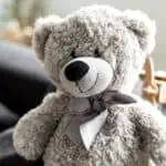 gray teddy bear with bow around neck