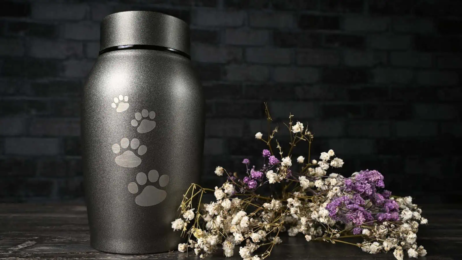 urn with paw prints on it next to flowers