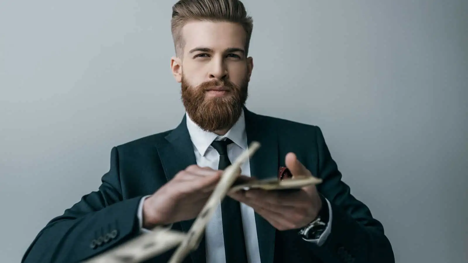 bearded young man throwing money