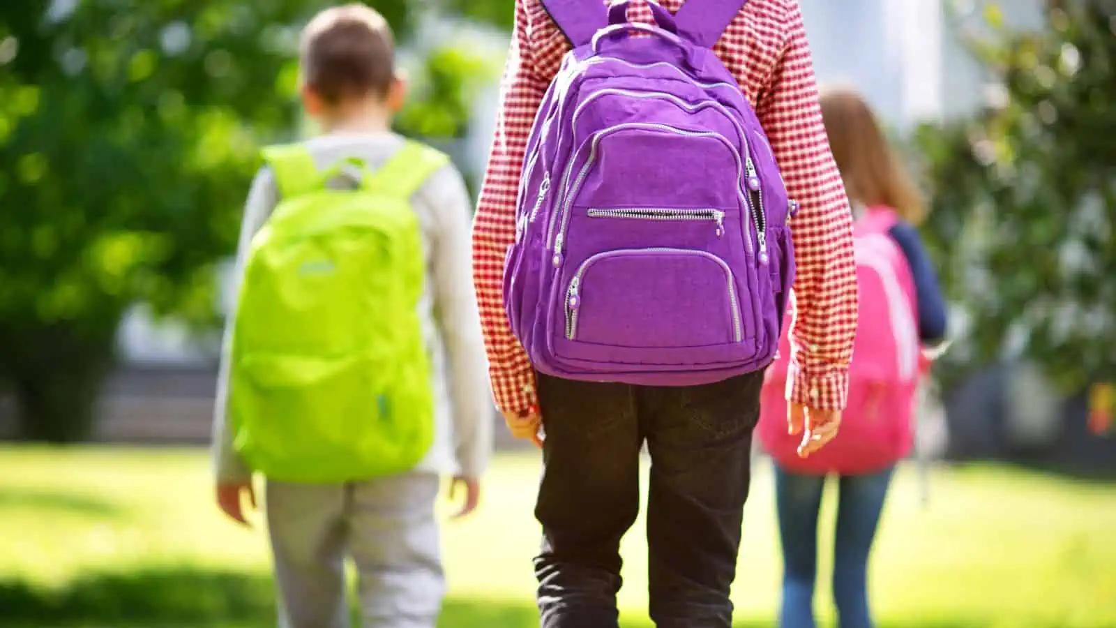 children walking outside with backpacks on