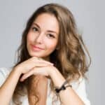 happy woman sitting with hands by face