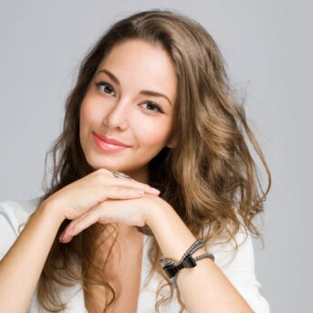 happy woman sitting with hands by face