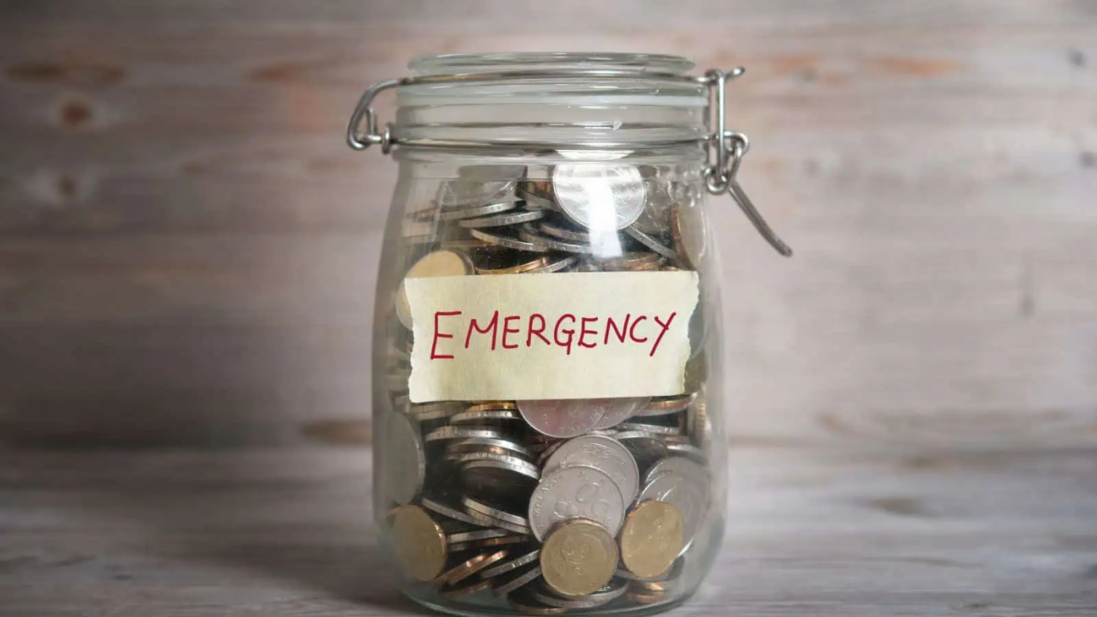 jar filled with coins and label saying emergency