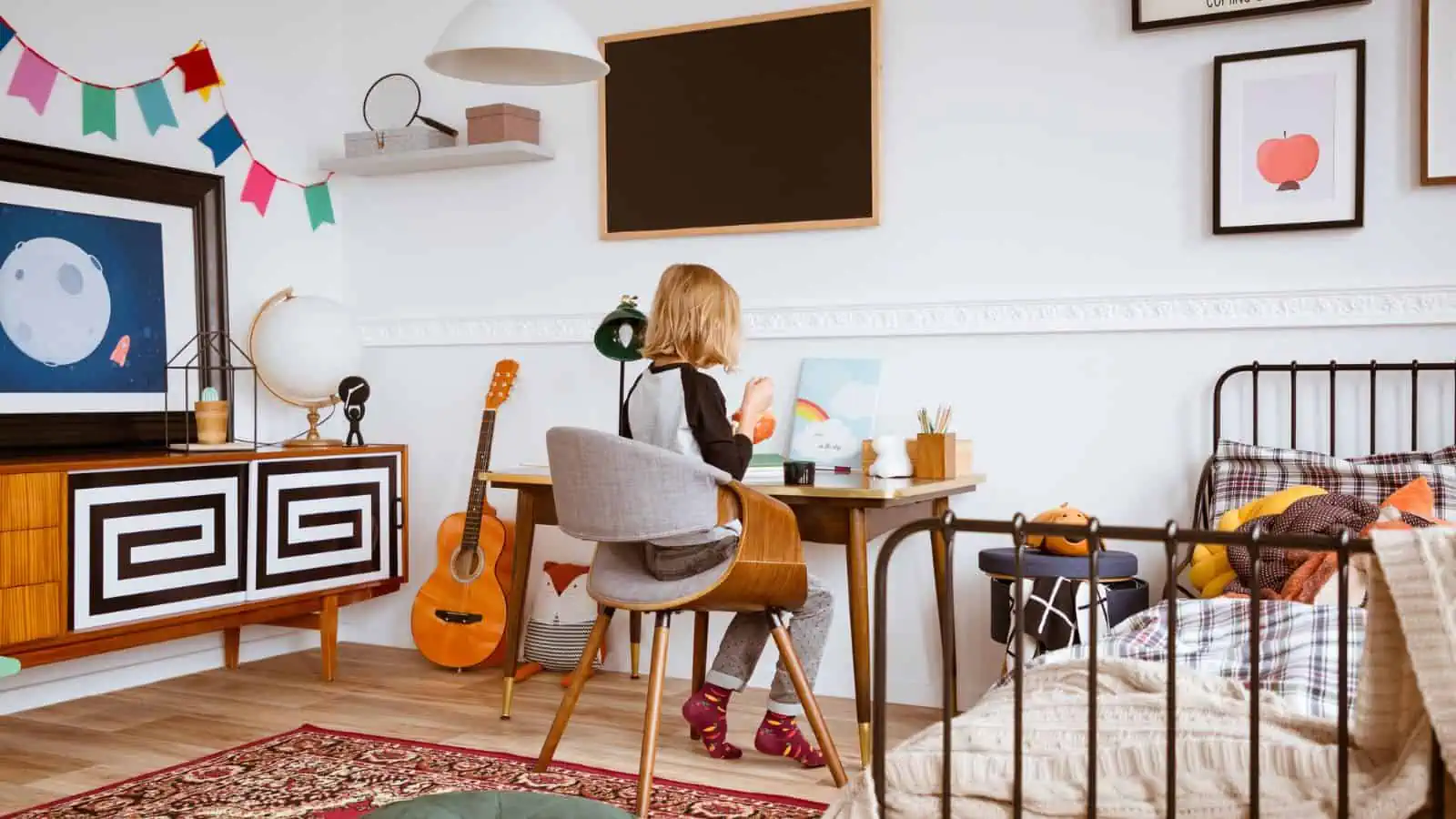 little boy sitting at desk in bedroom