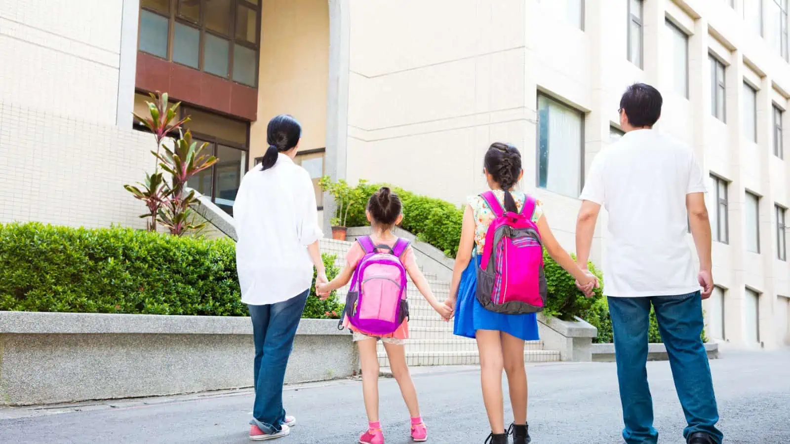 parents and two daughters with backpacks