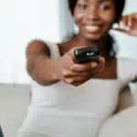 smiling woman holding remote control
