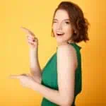 woman in green dress winking and pointing