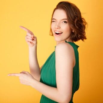 woman in green dress winking and pointing