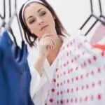 woman looking through clothes on hangers