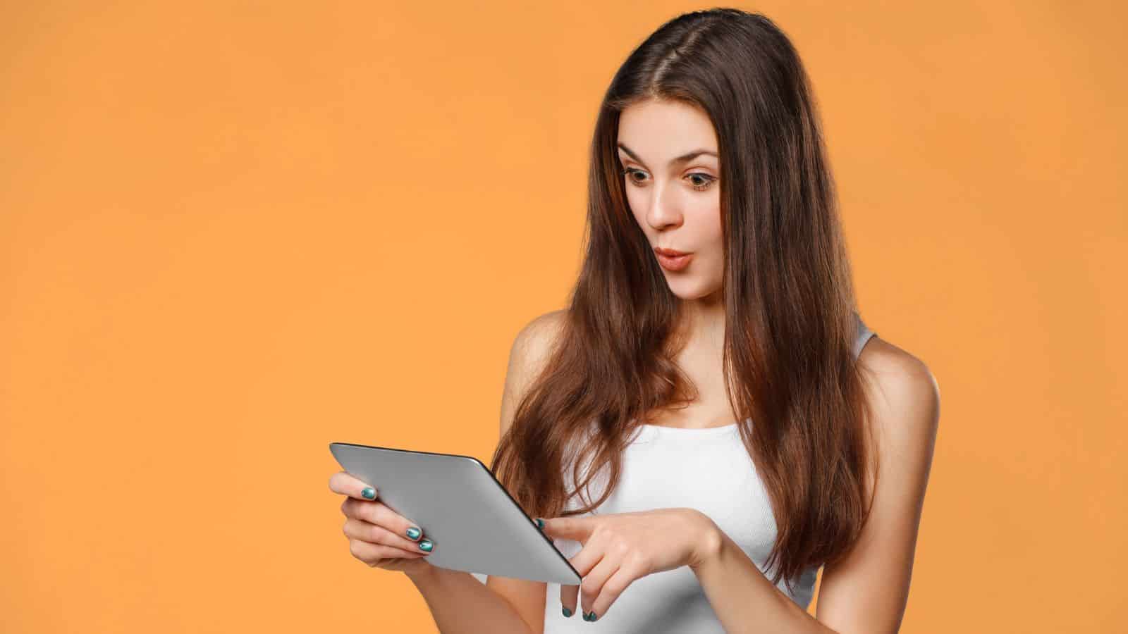 woman on tablet orange background