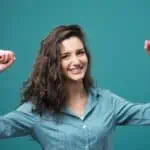 woman smiling and holding arms up