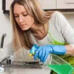 Blonde housewife cleaning furniture