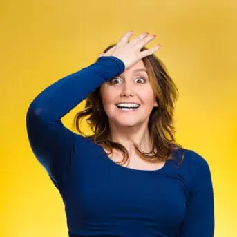Woman placing hand on head, palm on face gesture in duh moment