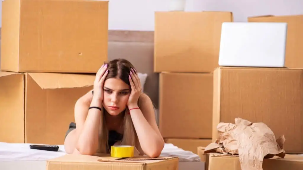 Upset and tired young woman decluttering