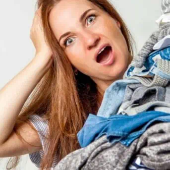 shocked woman with large pile of clothes
