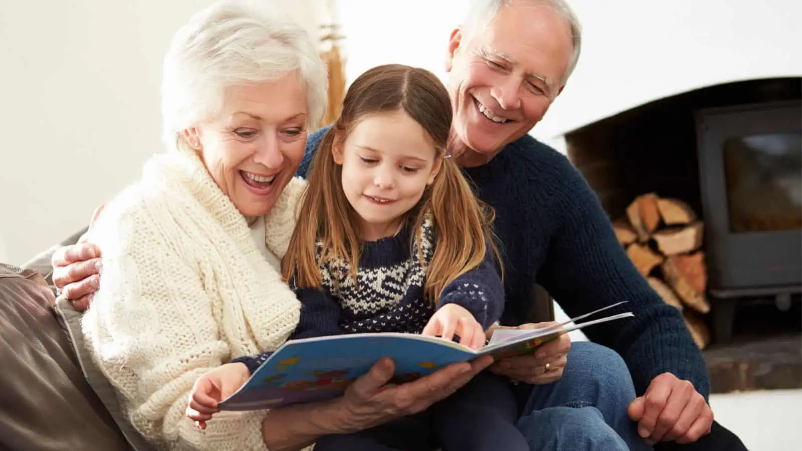 grandparents reading a book to granddaughter
