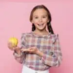 smiling girl holding an apple