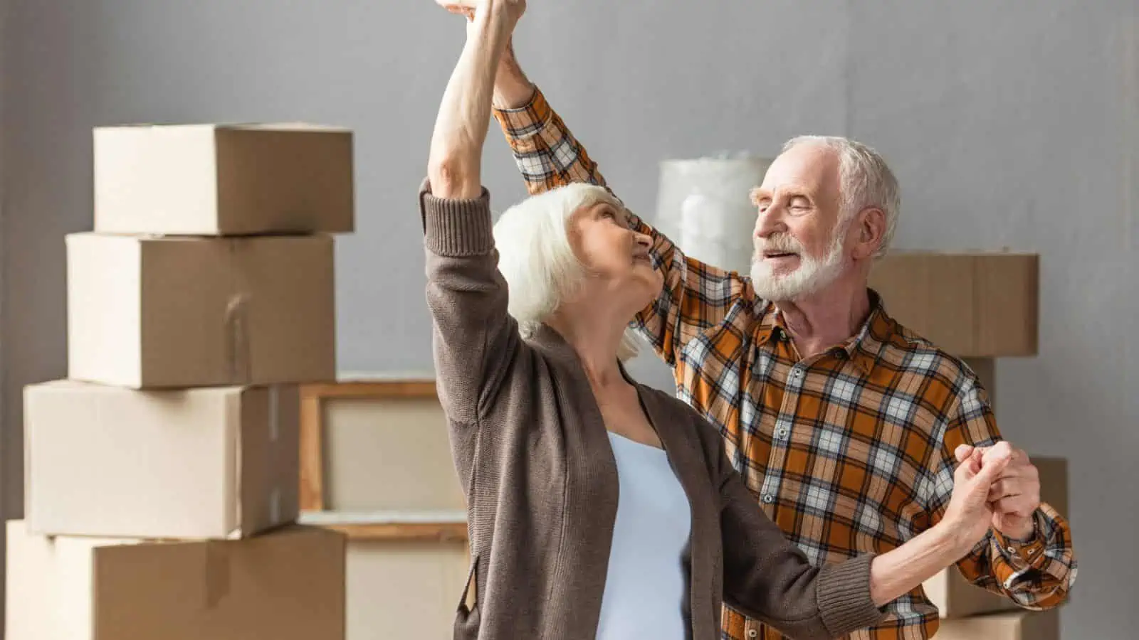 older couple dancing around moving boxes