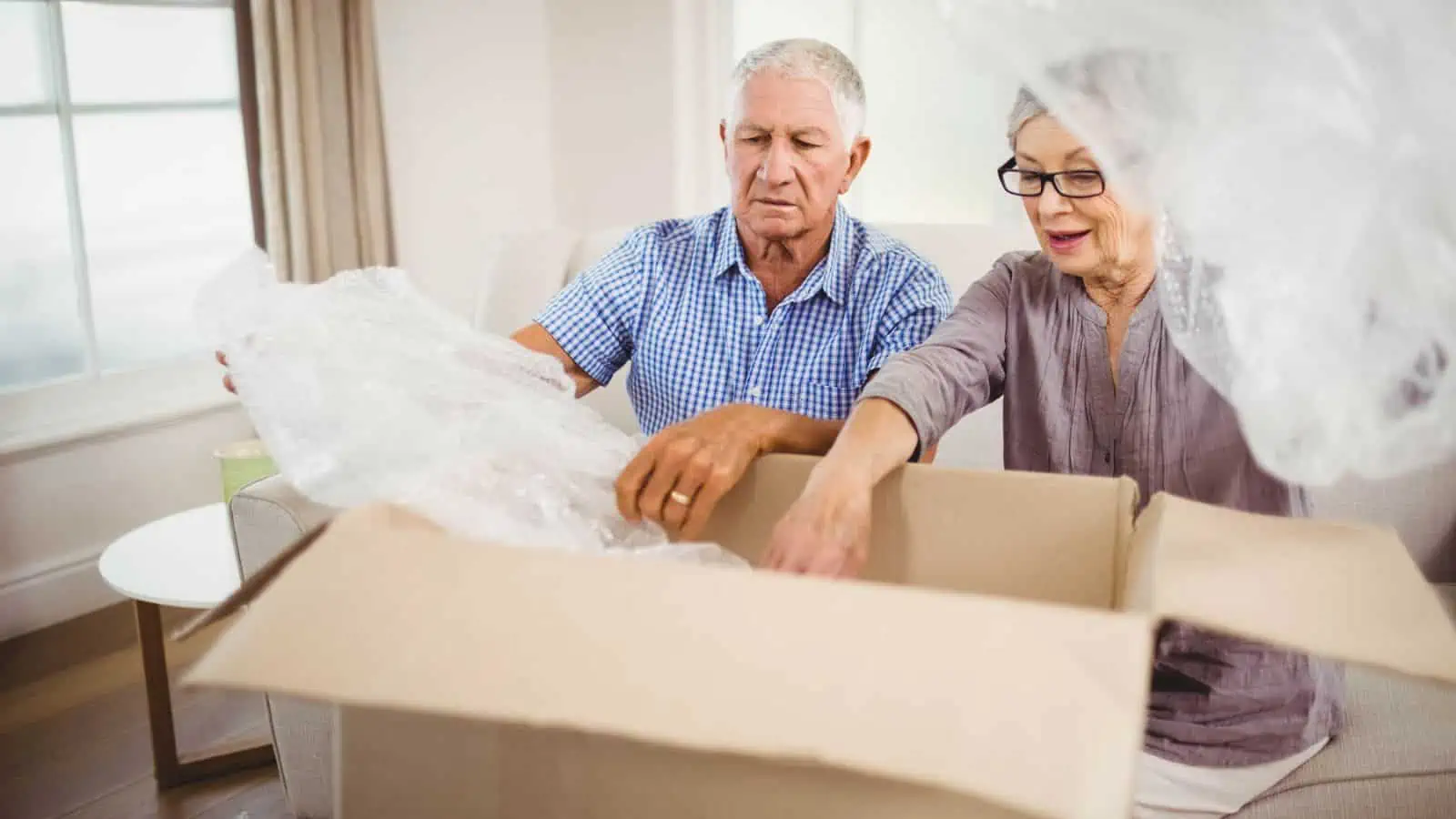 older couple packing moving box