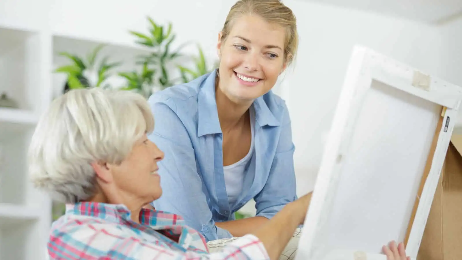 older woman showing younger woman a canvas