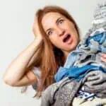 shocked woman with large pile of clothes