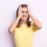 stressed woman with hands on her head