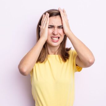 stressed woman with hands on her head