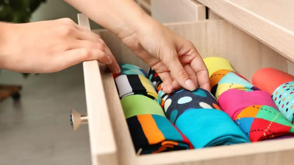 two female hands reaching into an organized sock drawer