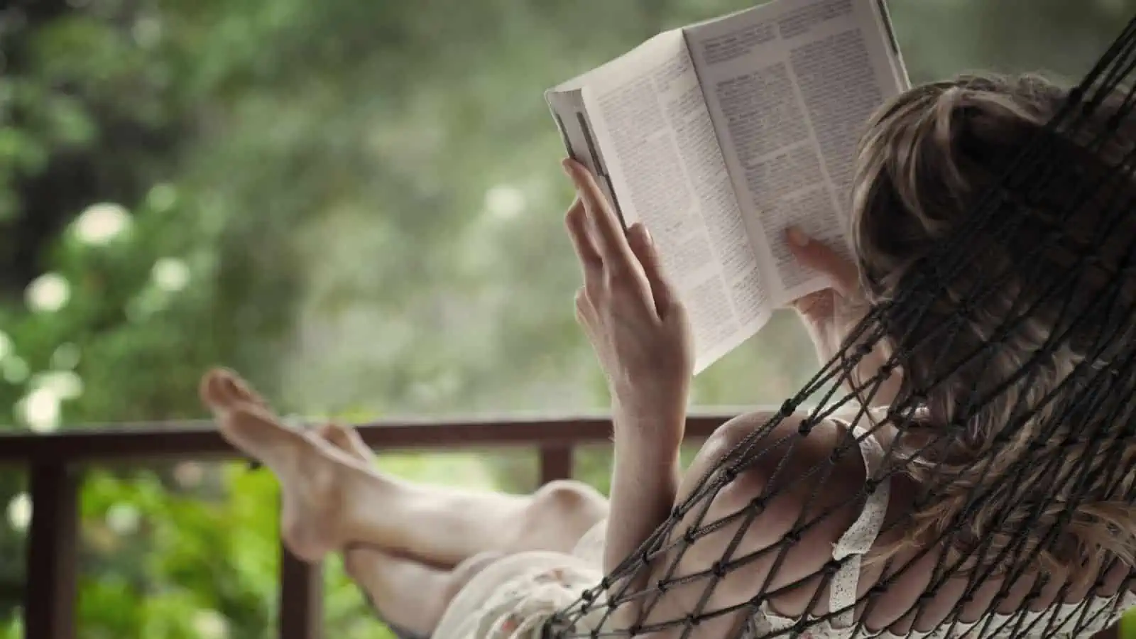woman reading a book in a hammock