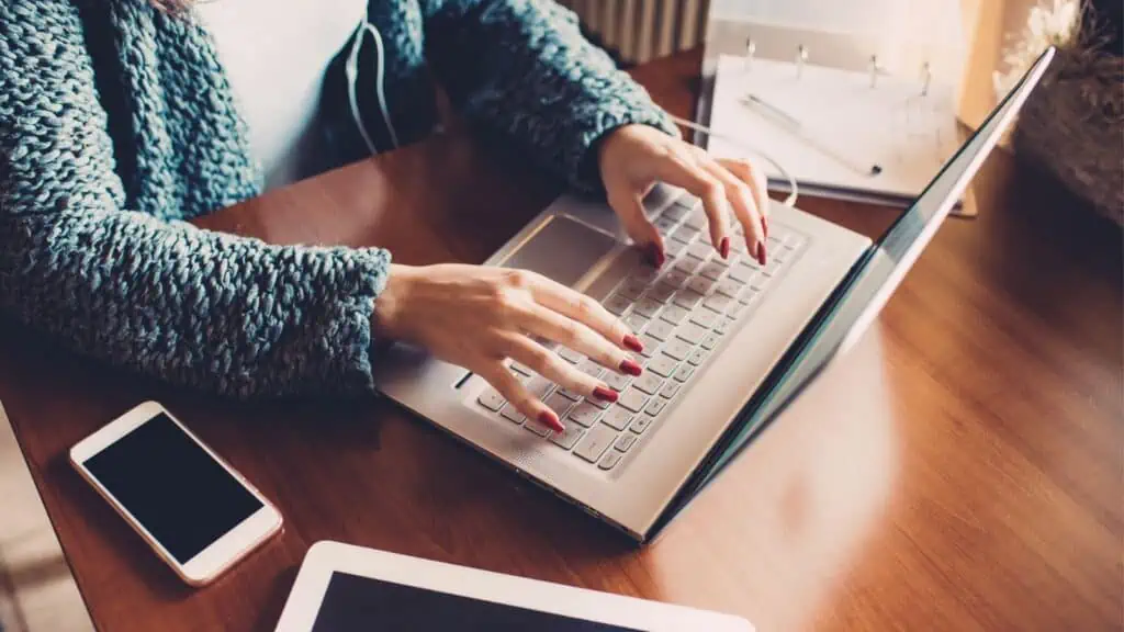 woman with red nails working on computer