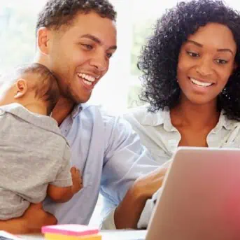 young family with baby working on computer