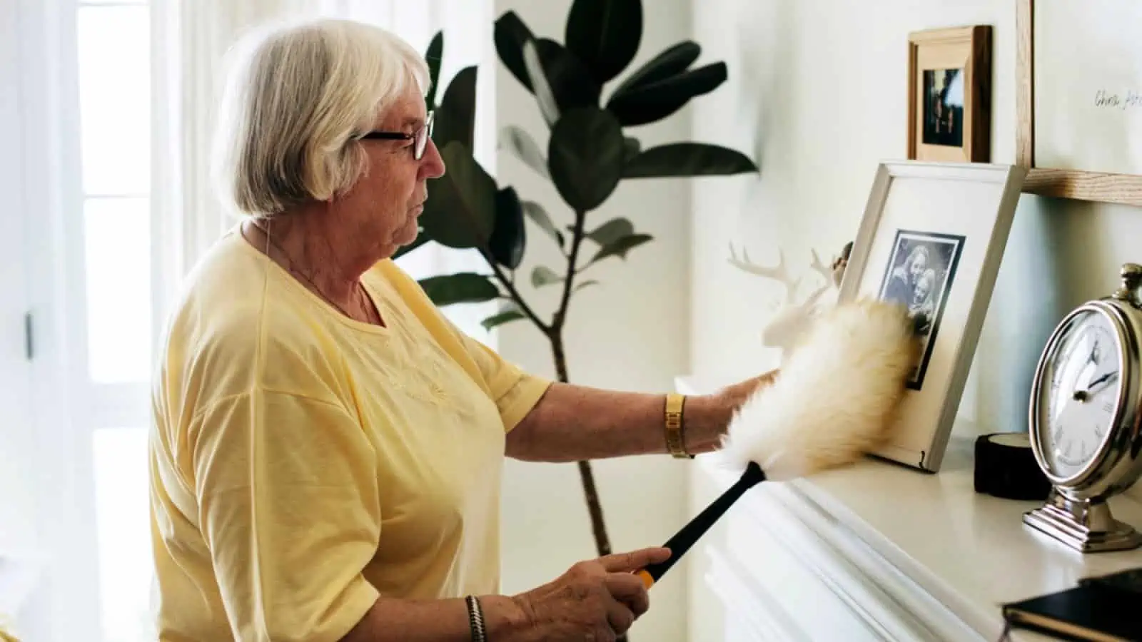 Old lady dusting photos