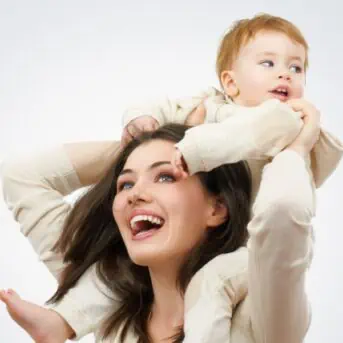 mom holding baby on shoulders