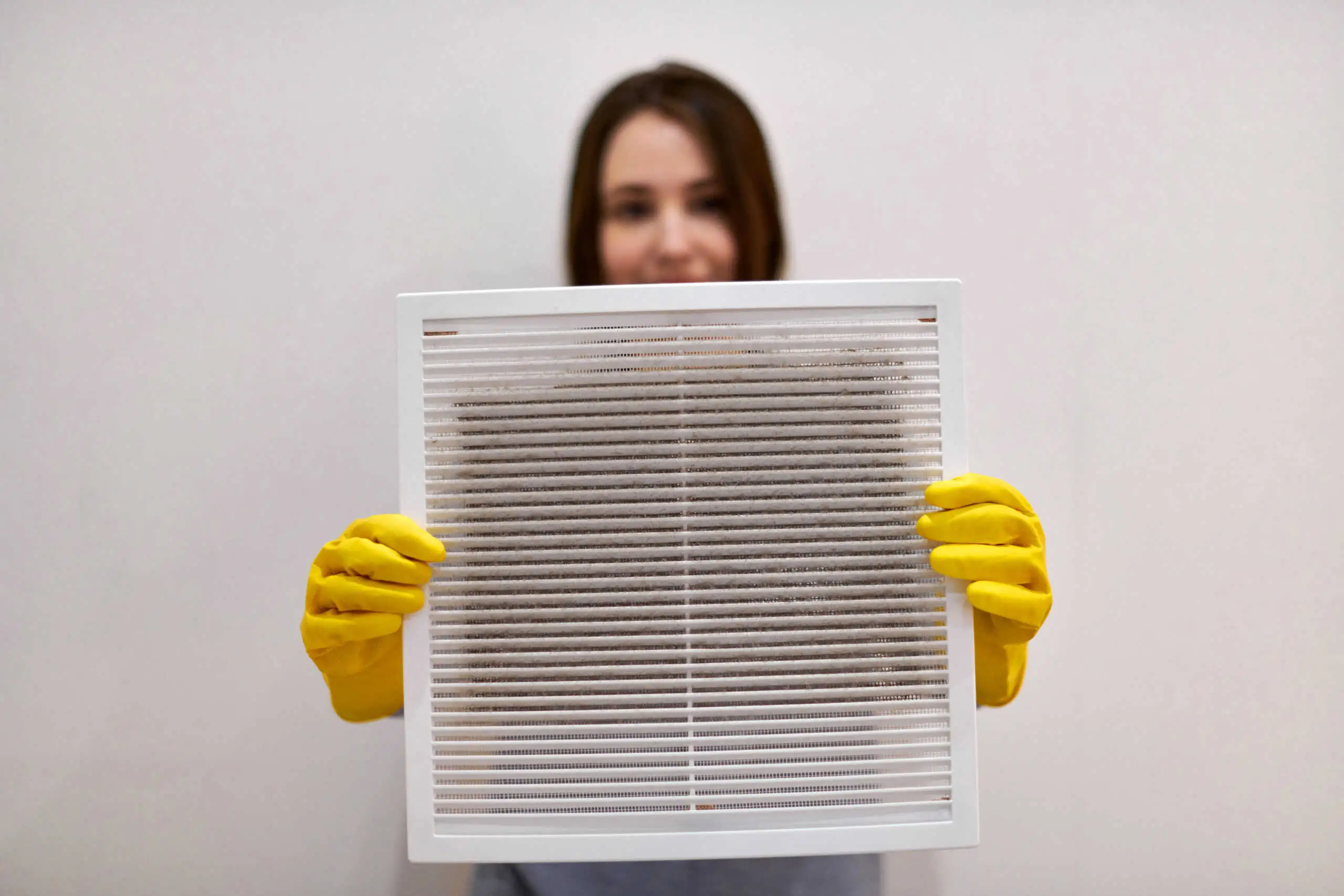 Woman holds ventilation filter to clean it