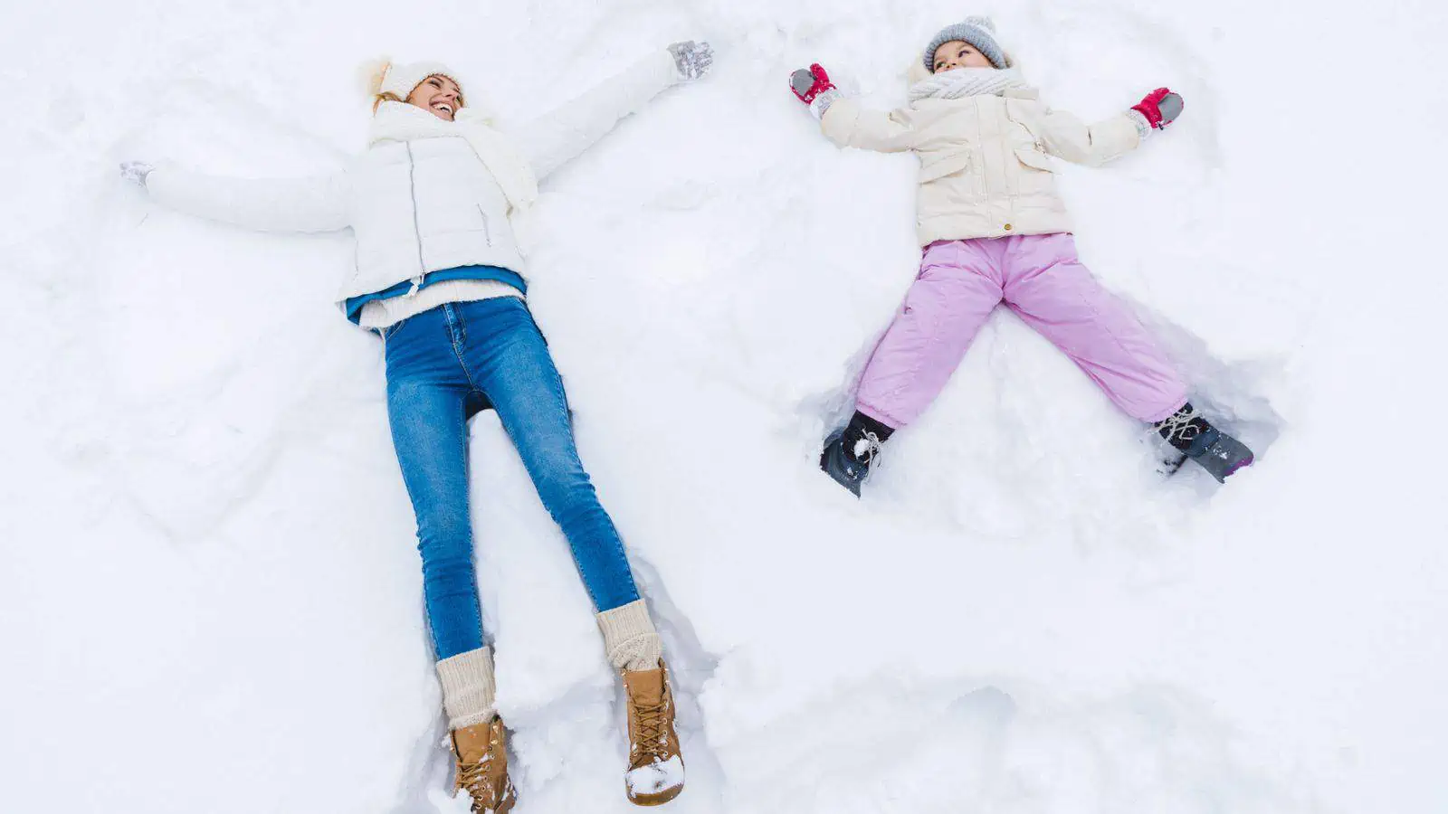 woman and child making snow angels
