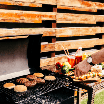 man cooking burgers on a grill