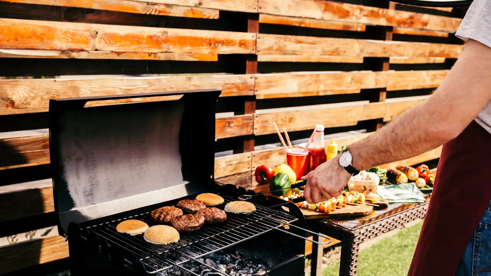 man cooking burgers on a grill