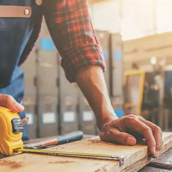 man measuring wood