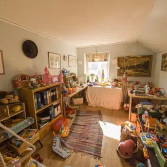 cluttered playroom with surfaces covered in toys